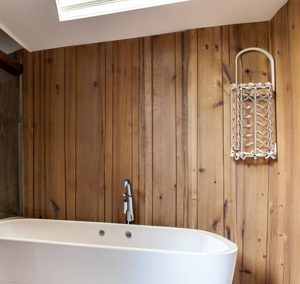 bathroom with a bathtub, made of wood.