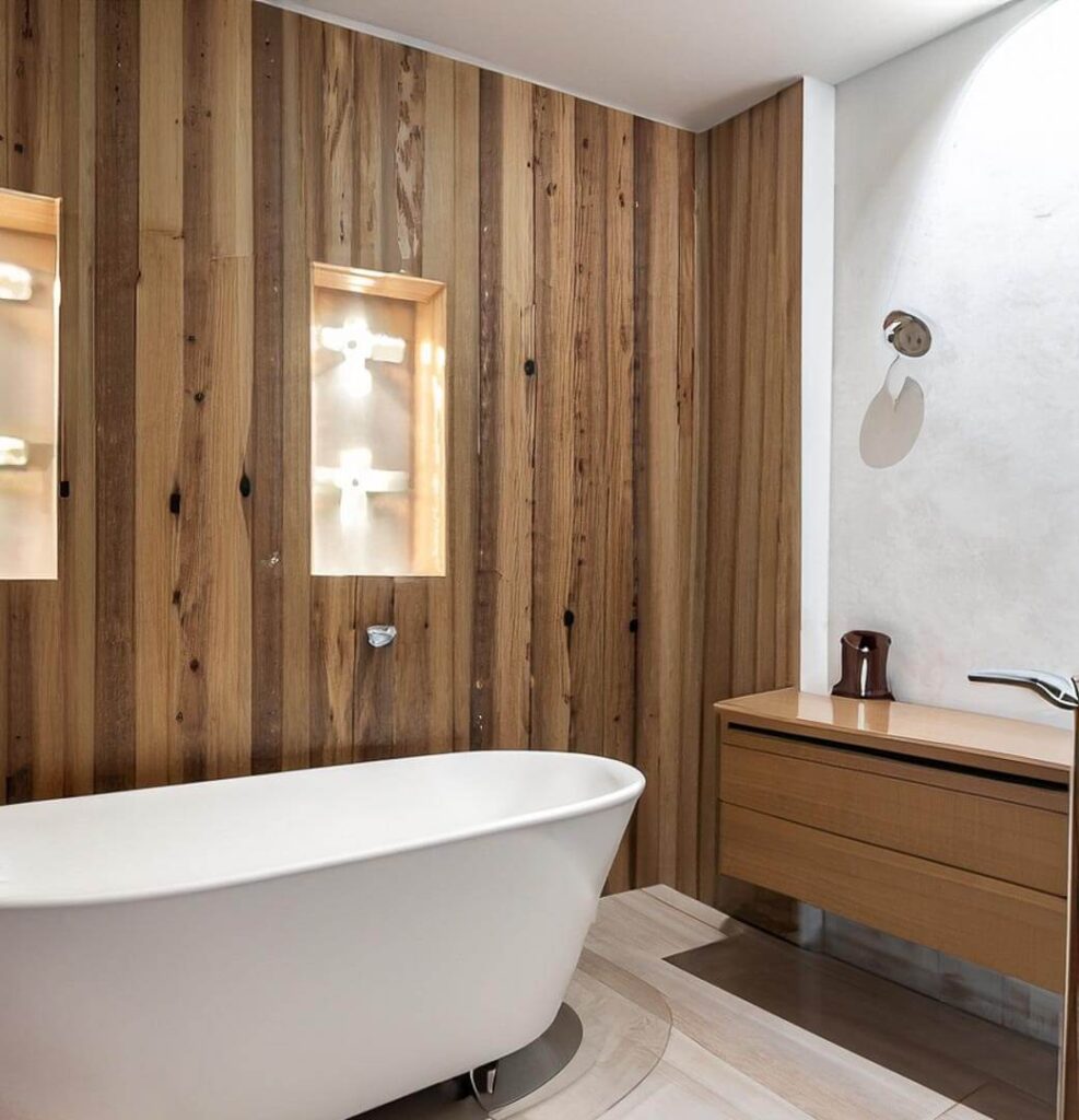 bathroom with a bathtub, light brown walls, walls made of wood and most of the details too like the washbasin