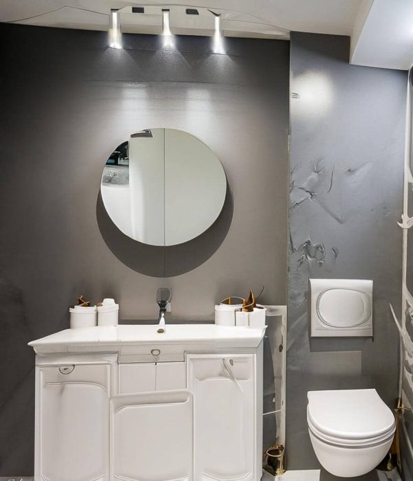 small bathroom, with a toiled, mirror, gray details,g light gray wall