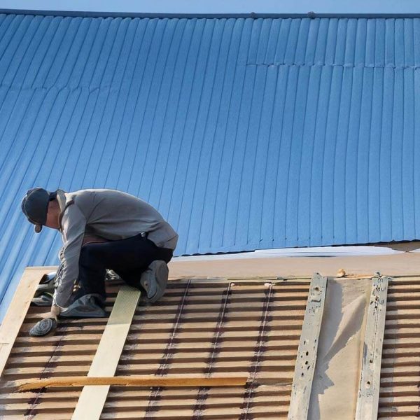 man doing aroof instalation, blue roof